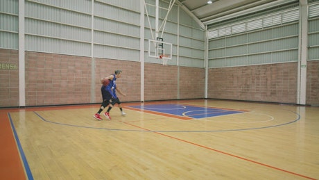 Two basketball players playing against each other.