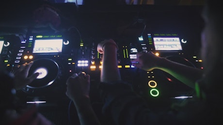 Two DJs mixing music at a club.