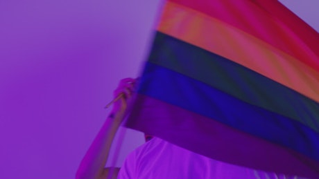 Two gay men waving the LGBT pride flag.