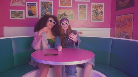 Two girls dancing in a retro restaurant.