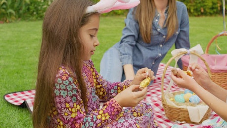 Two little girls eat their easter egg surprise.