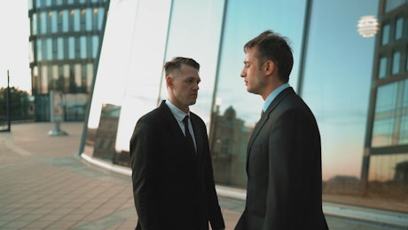 Two men in suits arguing.
