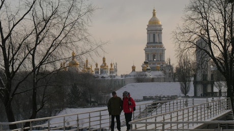 Two men walking through a city under the snow