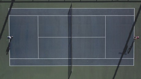 Two people playing tennis aerial view.