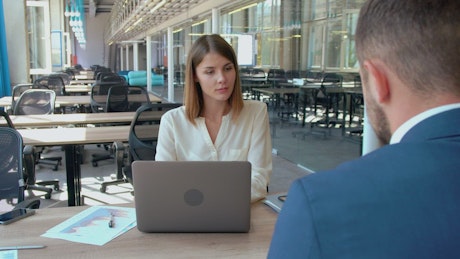 Two people working in a large office.