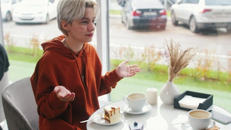 Two women chatting at a coffee shop.