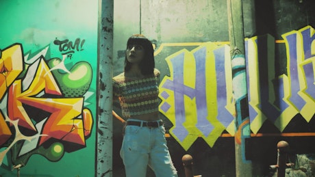 Urban woman near wall with graffiti