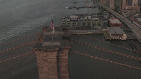 USA flag waving on the Brooklyn Bridge.