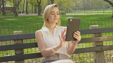 Using a tablet on a park bench.