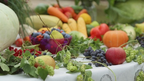 Vegetables and fruit on a table with a white tablecloth.