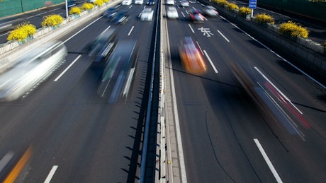 Vehicles traveling fast on a highway in the city.