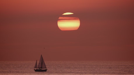 View of the horizon in the sea while a sailboat sails.
