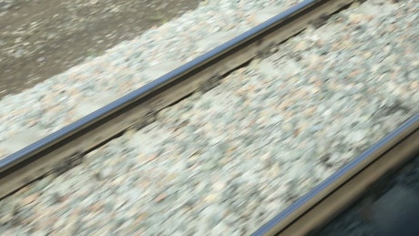 View of the railway tracks from a moving train.