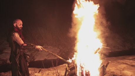 Viking lights torch with bonfire.