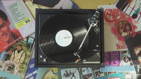Vintage turntable surrounded by many albums.