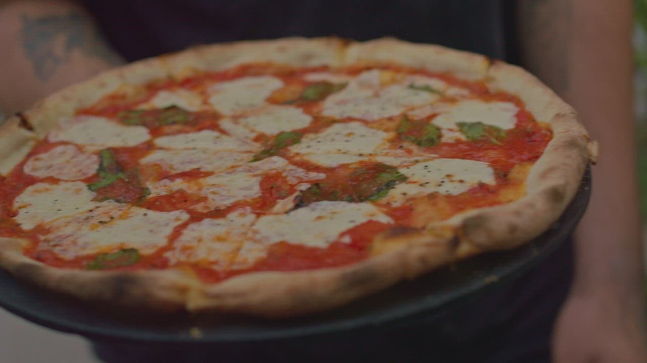 Pelaya 888 slot n menyajikan pizza di meja