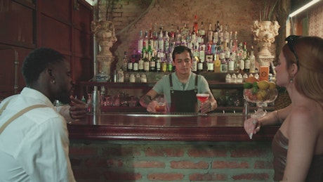 Waiter serving drinks to a couple in a bar