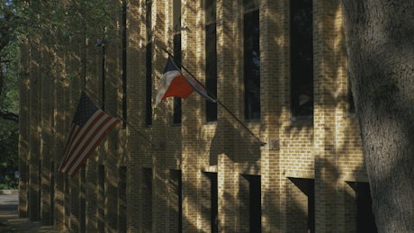 Wall of a buildings with American and Texas flags.