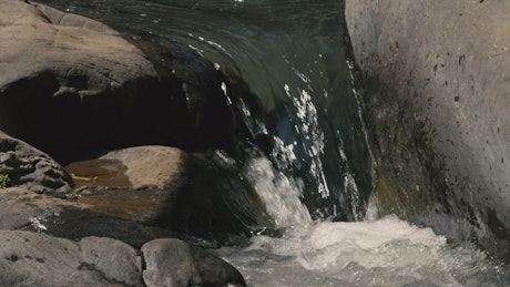 Water falls between rocks.