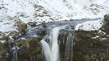 Waterfall of a river in winter falling into a canyon