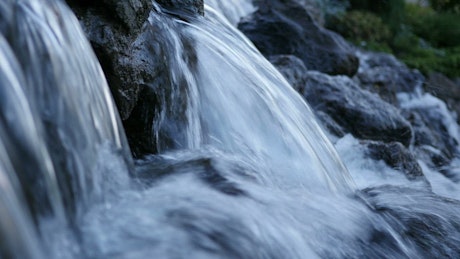 Waterfall over black stones