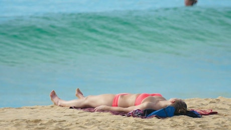 Wave crashing in the beach with a girl in bikini