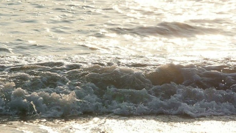 Waves creating foam at the coast.