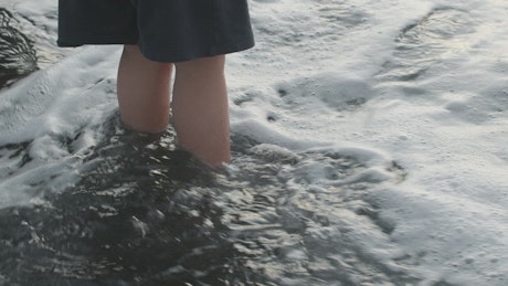 Waves washing over feet.