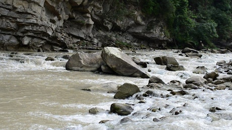 Wide river flowing over rocks and stones