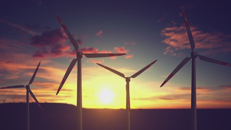 Wind turbines farm in a beautiful sunset background.