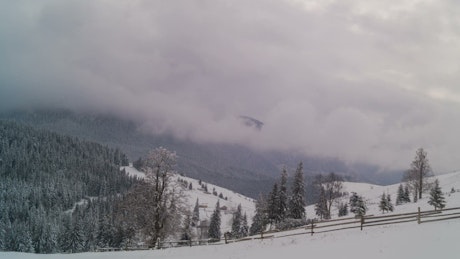 Winter mountain with fence and cloudy sky