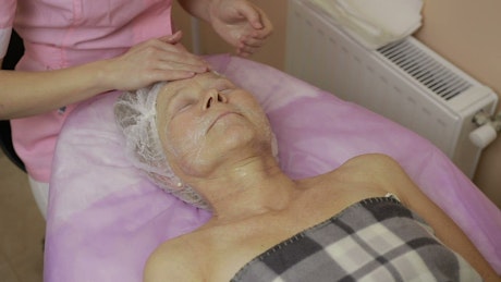 Woman applying a face treatment.