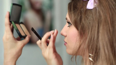 Woman applying make up.