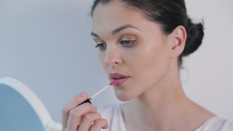 Woman applying makeup on her lips.
