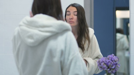 Woman checking her face in the mirror