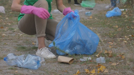 Woman collecting rubbish from a park