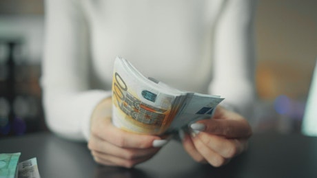 Woman counting euros bills.
