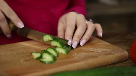 Woman cutting cucumber