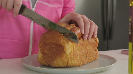 Woman cutting slices of sliced bread.
