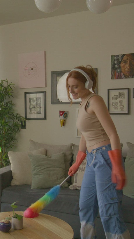 Woman dancing happily when cleaning her house