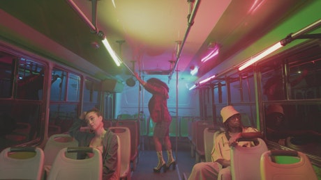 Woman dancing on a bus at night
