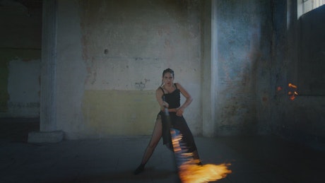 Woman dancing with a saber lit on fire