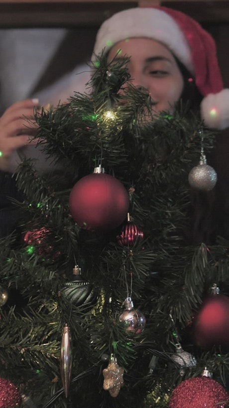 Woman decorates Christmas tree at home