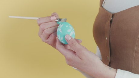 Woman decorating an egg.