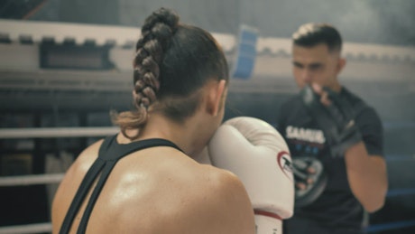 Woman doing kickbox movements with a coach.