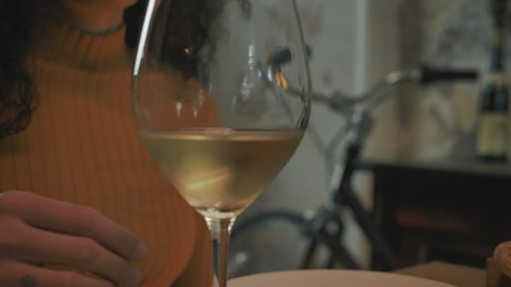 Woman drinking cold white wine from a glass.