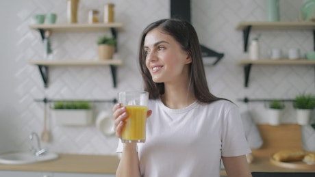 Woman drinking orange juice in the morning.