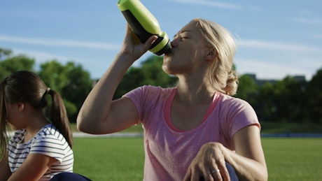 Woman drinking water after exercising.