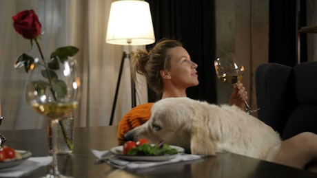 Woman drinking wine with her dog