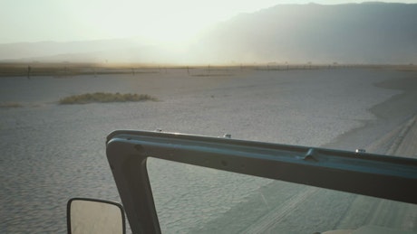 Woman driving a Jeep through a desert.